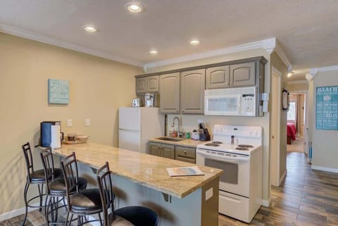 The kitchen has full-size appliances including a stove, oven, and fridge