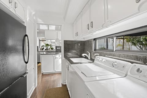 Off of the kitchen is the butler's pantry with secondary fridge and freezer, full laundry appliances, sink, and windows that look out to the courtyard.