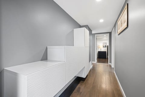 Ground floor main hallway leads between front entry door to rear garage access door. Primary bedroom, Bedroom #3 and main hallway bath also located here.