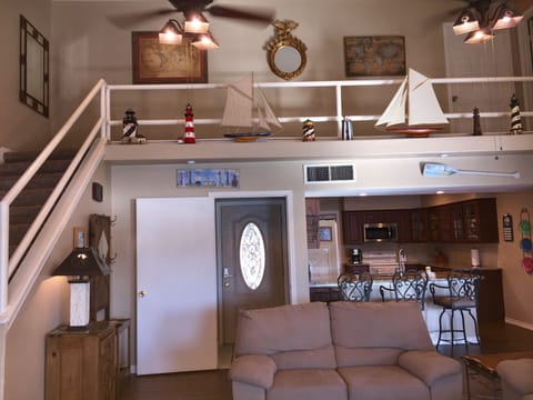 Large living room with high ceiling and 60 inch TV.