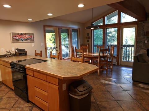 Open kitchen and dining space with two doors opening to balcony