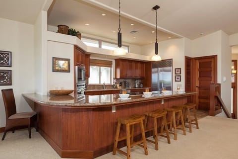 Full kitchen with breakfast bar, granite counters, and stainless steel appliances