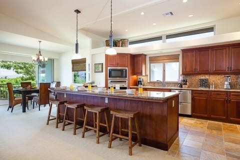 Full kitchen with breakfast bar, granite counters, and stainless steel appliances