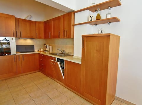 The kitchen area with dishwasher, oven, 4 electric ceramic hobs, fridge with freezer area, kettle, coffee machine