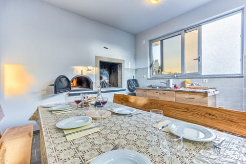 Standalone kitchen with stone barbecue and wood-fired pizza oven