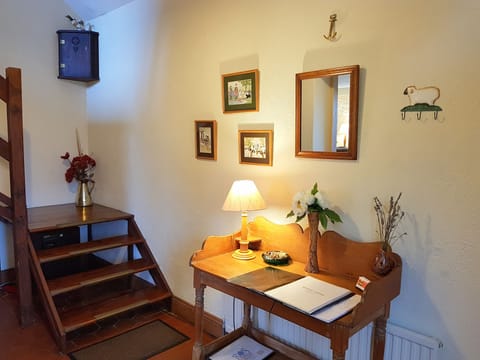 The cottage hallway has a high ceiling and stairs to Main Bedroom