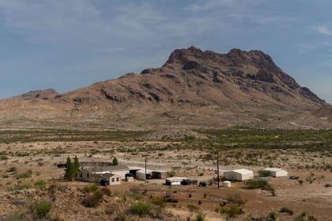 Ranch Compound with main Ranch House, three carports (one used for gatherings), game shack, wildlife feed paddock, East Corazones Peak in background