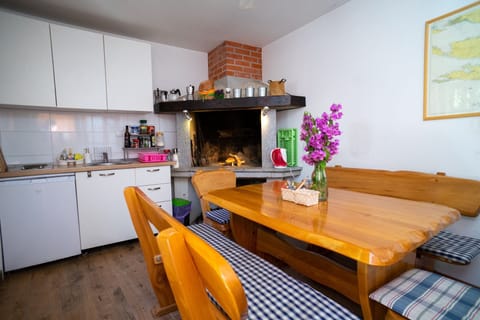 the house has a summer kitchen with a big breakfast table, a coffee machine, BBQ