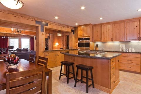 This expansive, upgraded kitchen boasts ample counter space and modern amenities, opening directly to the back deck and BBQ area, making it ideal for both indoor and outdoor cooking