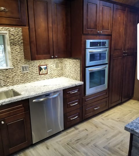Lots of cupboard space, stacked stone backsplash and double oven with microwave
