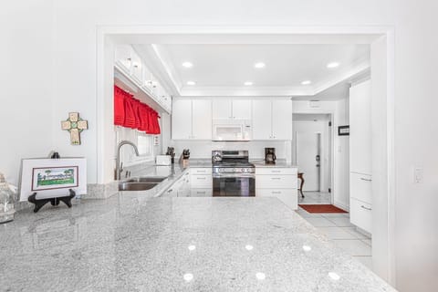 A breakfast bar with seating for two looks into the kitchen, making meal prep a social affair!