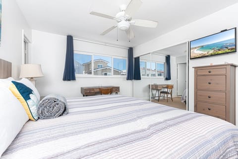 Bedroom #5 includes a king bed, TV, en suite bathroom, and sliding glass door to private rear deck w/ seating.