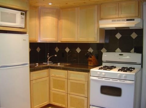 Kitchen with gas range, granite countertops, custom maple cabinets.