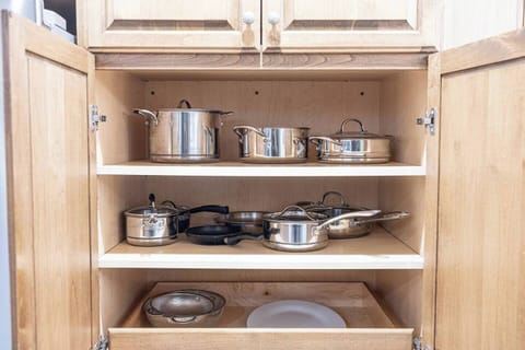 The kitchen is well stocked with cookware, utensils, silverware, and glassware.