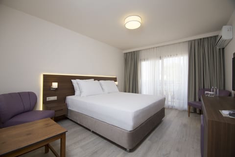 Deluxe Room, Partial Sea View | Premium bedding, minibar, in-room safe, desk