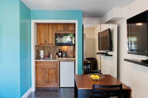 Small kitchenette with cooktop, mini fridge, and a small dining table.