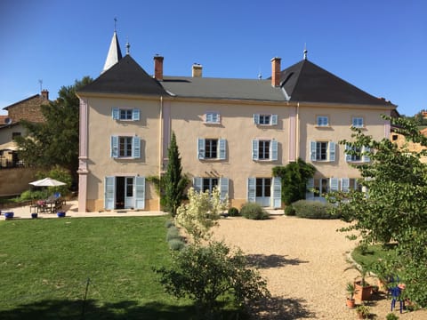 South facade with its french doors, terrace, lavendar wisteria and fruit trees.
