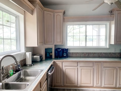 Lake views from and cabinets stocked for all of your cooking needs in kitchen.