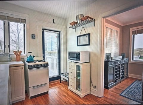 Kitchen with doorway to deck with gas Weber grill