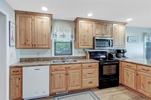 Kitchen with Stove, dishwasher, microwave. Cabinets full of dishes.