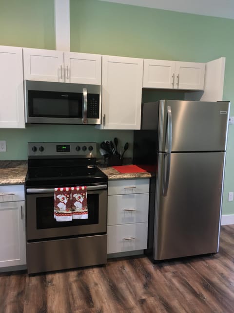 Full sized refrigerator with cabinets stocked with cooking supplies, dishes, etc
