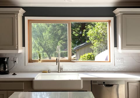 Large farmhouse sink below window with fire into the garden and towards the lake