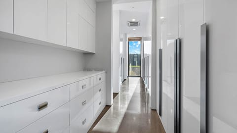 Sleek walk-in closet with ample storage and a bright window view.