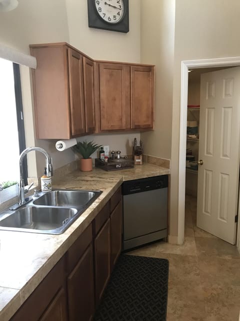 Kitchen has large walk-in pantry and stainless steel appliances.