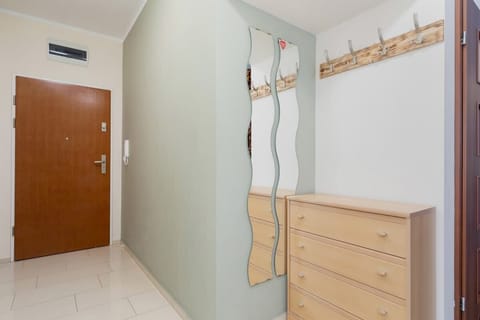A hallway with coat hooks, a storage unit, and a bright interior, offering convenience and organization.
