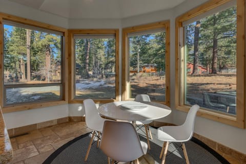 - Breakfast nook surrounded by windows with forest views
- Modern round table with seating for four in bright corner
- Peaceful space to enjoy morning coffee or casual meals