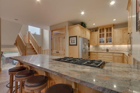 - Modern kitchen with granite counters and island
- Stainless appliances and spacious wood cabinetry
- Tahoe cabin rental with fully equipped kitchen