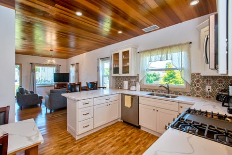 Kitchen showing living room, large windows and red cedar wood ceiling & internet