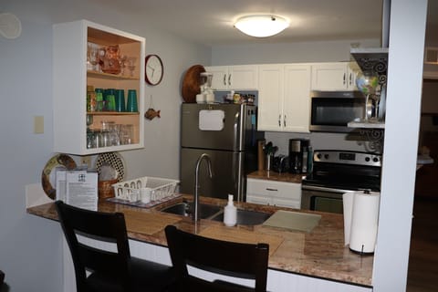 Fully stocked kitchen with glasses and dish ware for 5 people.