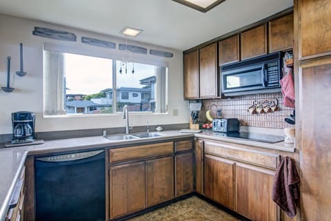 Kitchen with dishwasher, microwave and flattop stove.