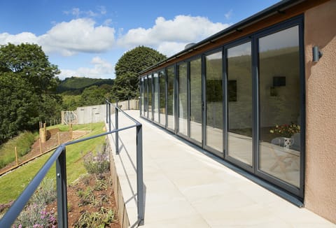 A staggering 16 metres of bi-folding doors opening out to a tiled balcony overlooking the beautiful river