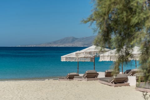 On the beach, white sand, sun loungers, beach umbrellas