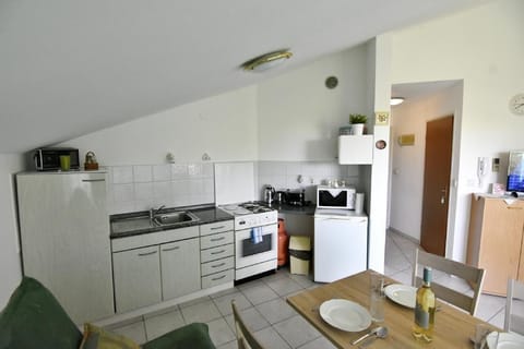 The kitchen is equipped with an oven, microwave, refrigerator, toaster, two gas, and two electric burners