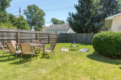 Spacious backyard with BBQ grill, outdoor furniture and corn hole game.