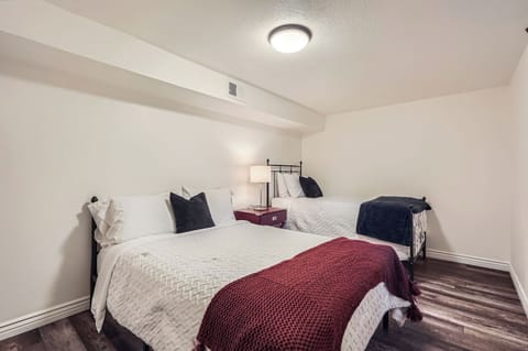 Basement bedroom with a full and a twin bed.