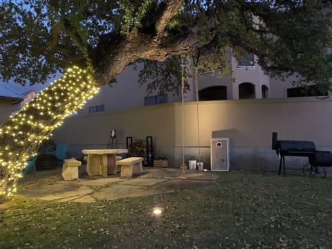Courtyard with fire pit area, outdoor chairs, a charcoal grill & cornhole set