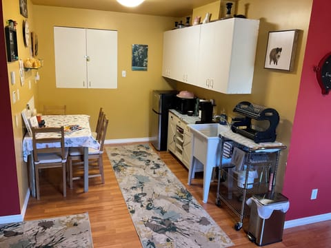 Compact kitchenette with fridge, sink, coffee, and cozy dining nook