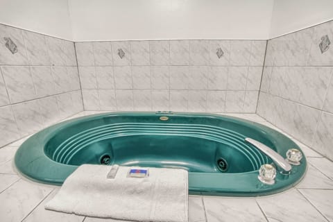 Deluxe Room, 1 King Bed, Non Smoking, Hot Tub | Bathroom | Combined shower/tub, hair dryer, towels, soap