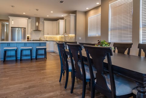 Alternate view of dining table and bar area with 3 barstools