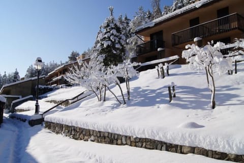 Sunny slope beside the residence surrounded by fresh snow and peaceful alpine scenery.