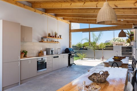 A shaded outdoor dinning area with a fully equipped kitchen & BBQ facilities.