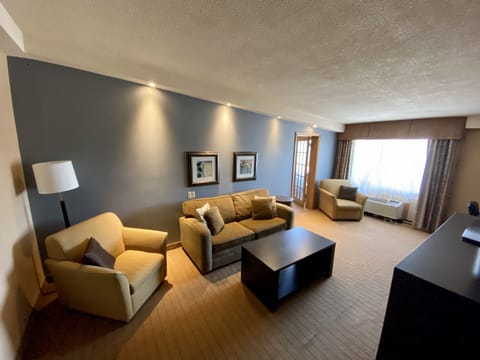 1 King Jacuzzi Suite | Living room | 55-inch Smart TV with cable channels, TV, books