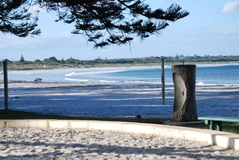 Beach nearby, white sand, beach towels, windsurfing