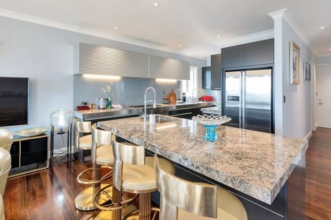 The kitchen island bench is a great place to sit on the golden bar stools and enjoy a casual meal.