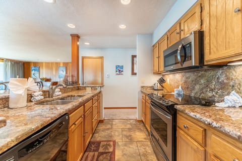 Full size kitchen with granite countertops and stainless steel appliances.