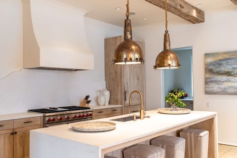 Kitchen Island, Stools, Refrigerator, and Ceiling Lamps.